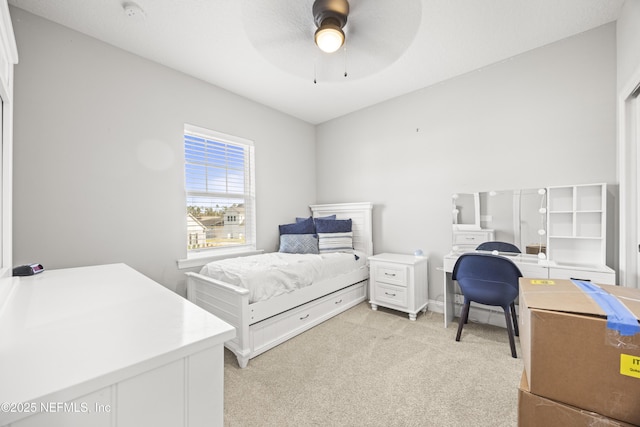 bedroom featuring light colored carpet and a ceiling fan