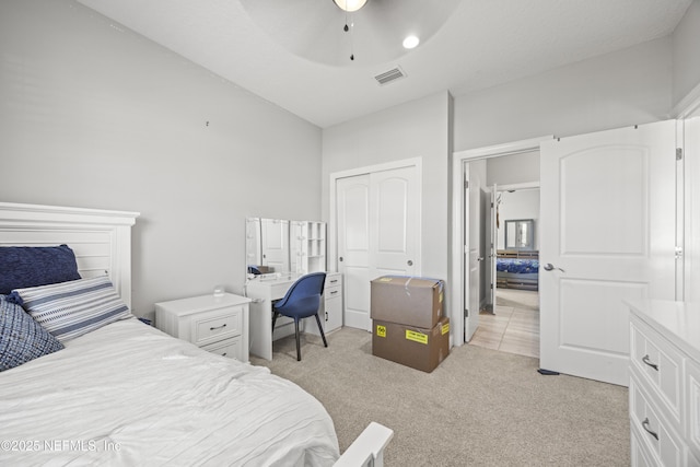 bedroom with a ceiling fan, light colored carpet, visible vents, and a closet