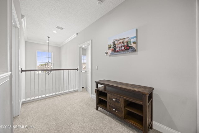 corridor featuring baseboards, a textured ceiling, an inviting chandelier, and carpet floors