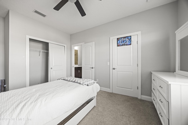 bedroom featuring visible vents, baseboards, light carpet, a closet, and a ceiling fan