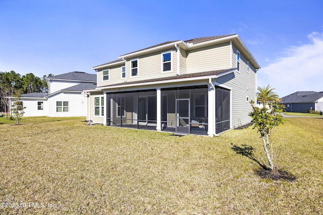 back of property with a yard and a sunroom