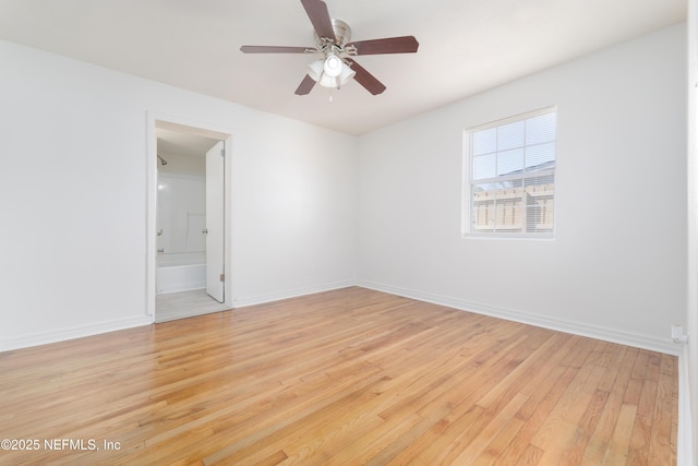 spare room with light wood-type flooring, ceiling fan, and baseboards