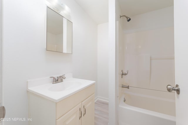 bathroom featuring wood finished floors, vanity, and washtub / shower combination