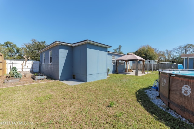 rear view of property with a fenced backyard, a garden, a gazebo, a yard, and a fenced in pool