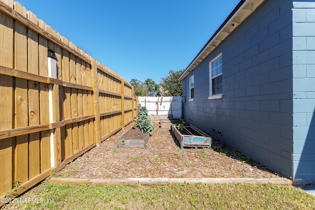 view of yard with a garden and a fenced backyard