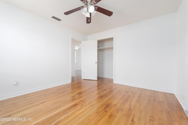 unfurnished bedroom featuring a closet, visible vents, light wood-style flooring, a ceiling fan, and baseboards