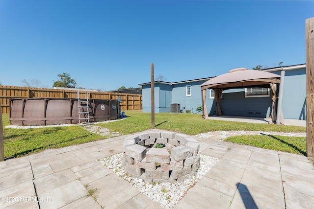 view of patio / terrace featuring a fire pit, a fenced in pool, fence, cooling unit, and a gazebo