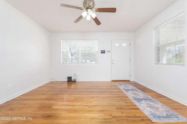 entrance foyer with a ceiling fan, light wood-style flooring, baseboards, and a wealth of natural light