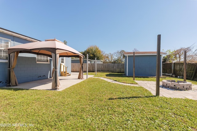 view of yard featuring a patio area, an outdoor fire pit, a fenced backyard, and a gazebo