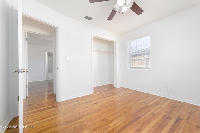 unfurnished bedroom featuring a closet, visible vents, light wood-style flooring, and baseboards