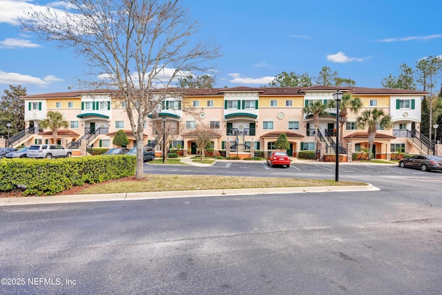 view of property with uncovered parking and a residential view