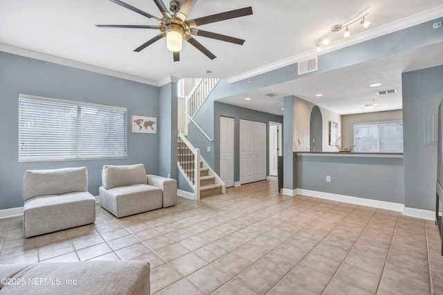 unfurnished living room featuring visible vents, crown molding, stairway, and baseboards