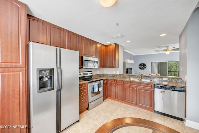 kitchen featuring stainless steel appliances, stone countertops, visible vents, and a sink