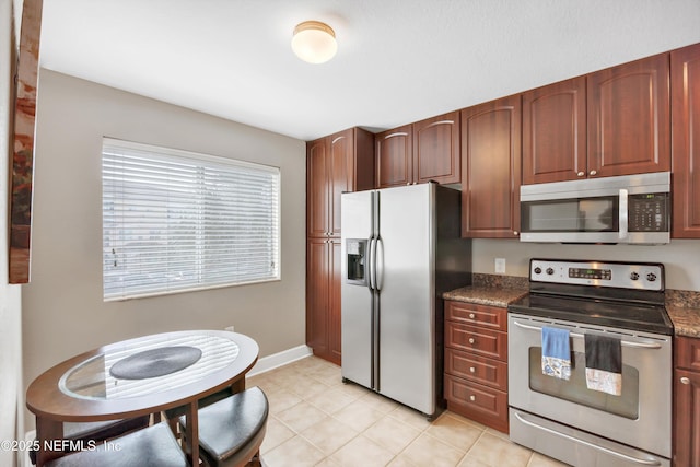 kitchen with stainless steel appliances, baseboards, and light tile patterned floors