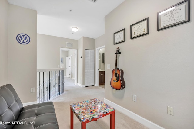 corridor with carpet floors, baseboards, and visible vents