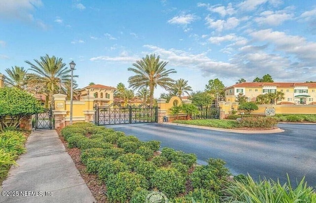 view of street featuring street lighting, a gated entry, a residential view, and a gate