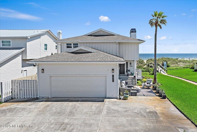 view of front of house with a garage, driveway, roof with shingles, and a front yard