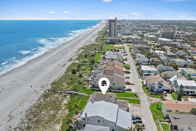 birds eye view of property with a water view and a beach view