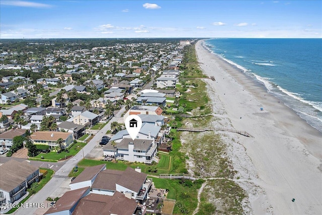 drone / aerial view with a water view, a residential view, and a view of the beach