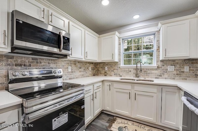 kitchen with stainless steel appliances, tasteful backsplash, light countertops, white cabinets, and a sink