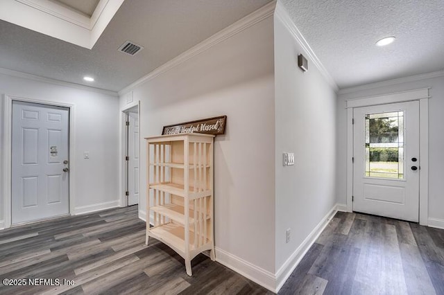 entryway featuring a textured ceiling, visible vents, baseboards, ornamental molding, and dark wood finished floors