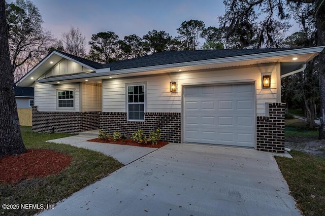 single story home featuring brick siding, concrete driveway, and a garage