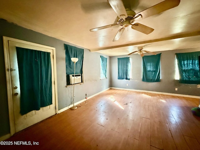 empty room featuring cooling unit, wood finished floors, a ceiling fan, and baseboards