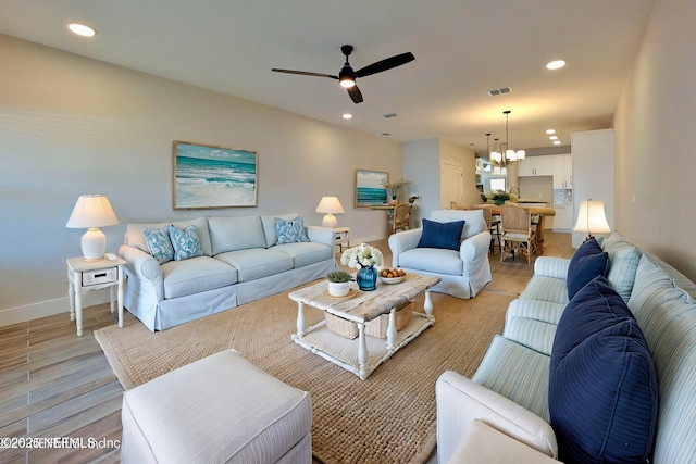 living room with light wood finished floors, baseboards, visible vents, and recessed lighting