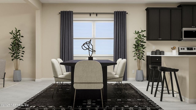 dining space with baseboards and light wood-style floors