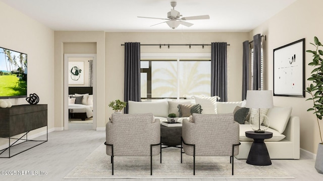 living area with baseboards and a ceiling fan