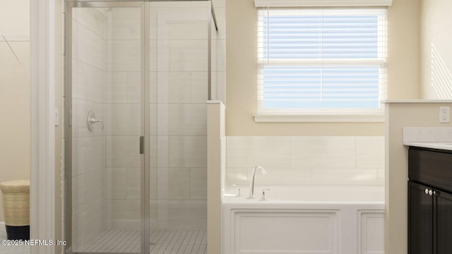 full bathroom featuring a bath, a shower stall, and vanity