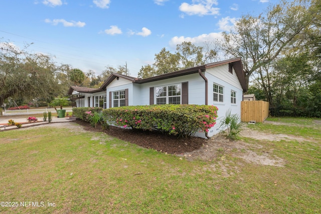 view of side of property featuring a yard and fence