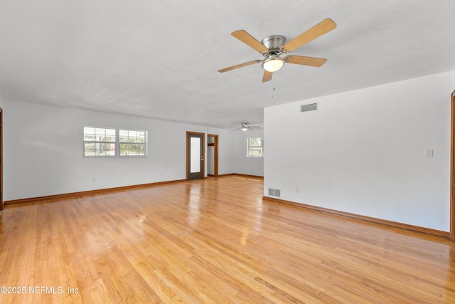 spare room featuring ceiling fan, light wood-type flooring, visible vents, and baseboards