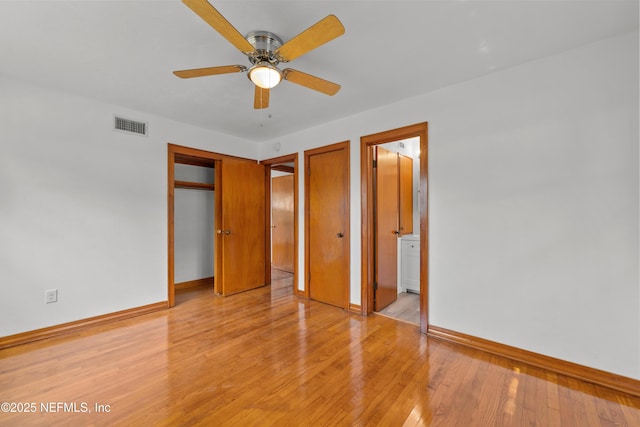 unfurnished bedroom featuring light wood-style floors, visible vents, connected bathroom, and baseboards