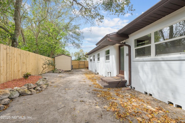 view of home's exterior featuring a storage shed, an outdoor structure, and a fenced backyard