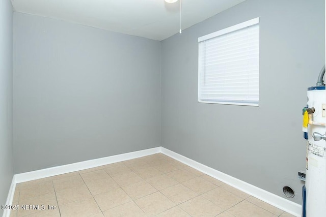 interior space with water heater, laundry area, tile patterned flooring, and baseboards