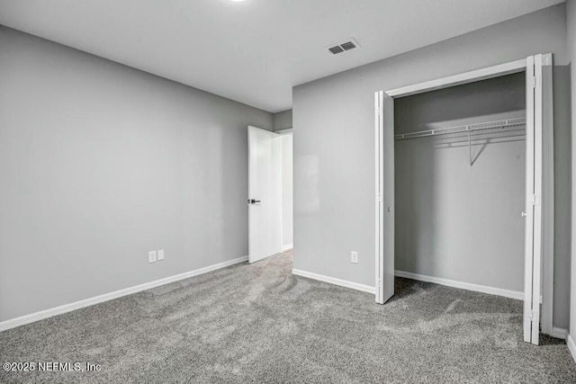 unfurnished bedroom with carpet floors, a closet, visible vents, and baseboards