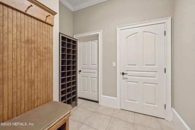 mudroom with light tile patterned floors, baseboards, and ornamental molding