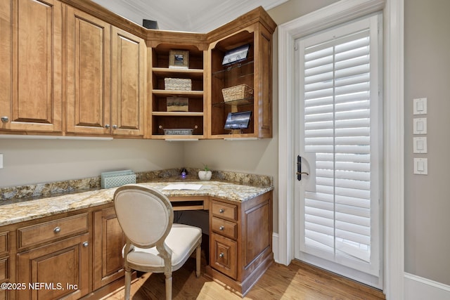 office area with light wood finished floors and built in desk