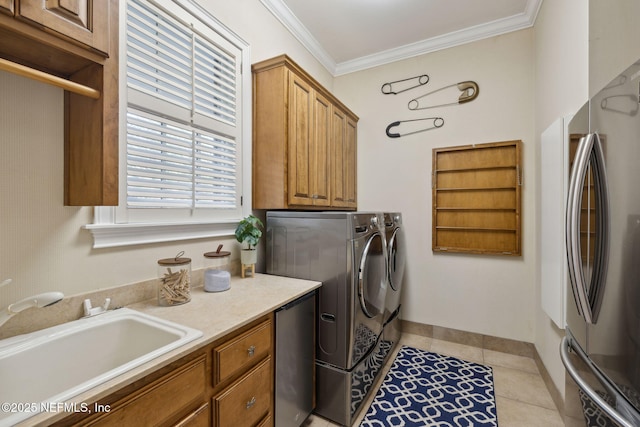 laundry room featuring light tile patterned flooring, a sink, ornamental molding, cabinet space, and washer and clothes dryer