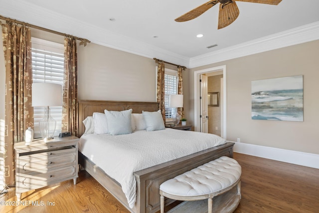 bedroom featuring visible vents, crown molding, baseboards, and wood finished floors