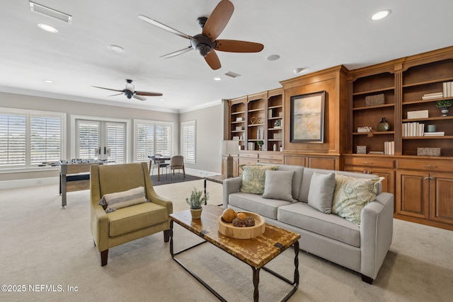 living room with ornamental molding, recessed lighting, visible vents, and light carpet