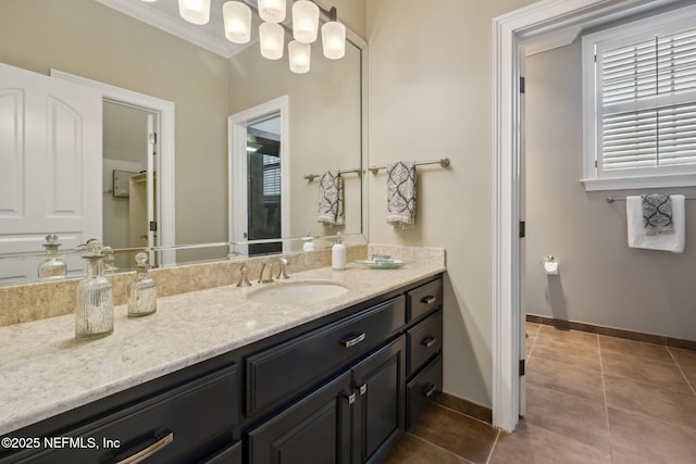 bathroom featuring tile patterned floors, baseboards, crown molding, and vanity