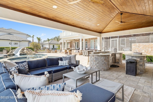 view of patio with a jacuzzi, a sink, outdoor dry bar, and an outdoor hangout area