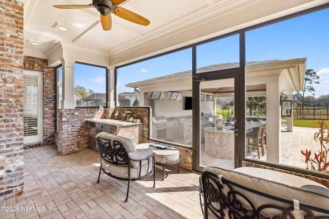 sunroom / solarium featuring ceiling fan