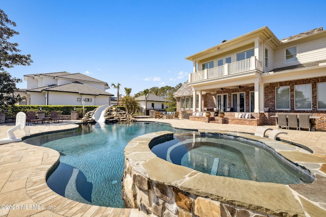 view of pool featuring a pool with connected hot tub, a water slide, a patio area, and ceiling fan