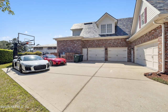 view of home's exterior with a garage, concrete driveway, and brick siding