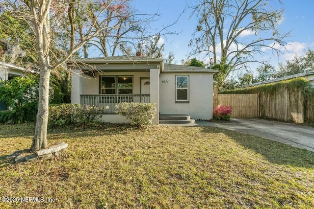 view of front of property featuring a porch, fence, a front lawn, and stucco siding