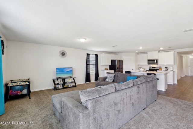 living room featuring baseboards, visible vents, and recessed lighting