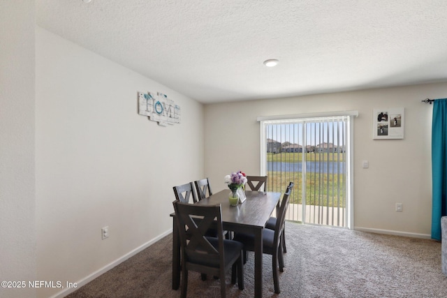 dining area with a textured ceiling, carpet flooring, and baseboards